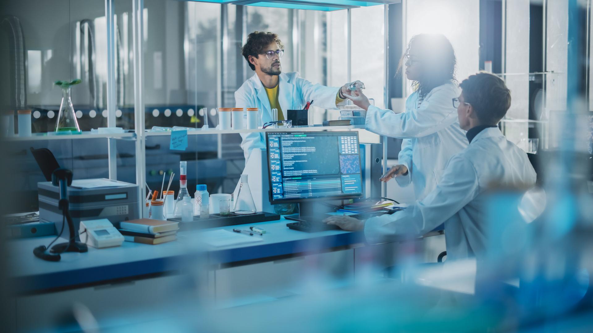 Modern Medicine Research Laboratory: Diverse Team of Multi-Ethnic Young Scientists Passes Samples in Petri Dish. Advanced Lab with High-Tech Equipment, Microbiology Researchers Design, Develop Drugs